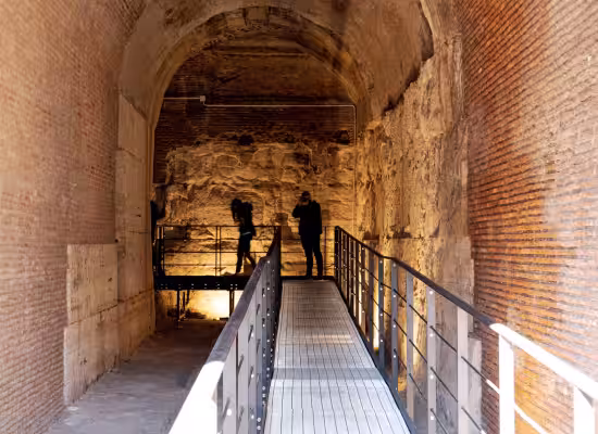 Visitors walking along a raised walkway inside the Colosseum Underground