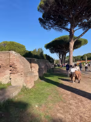 Visitors walking an ancient street in Ostia Antica