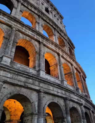 Colosseum arches glowing at dusk from a close exterior view