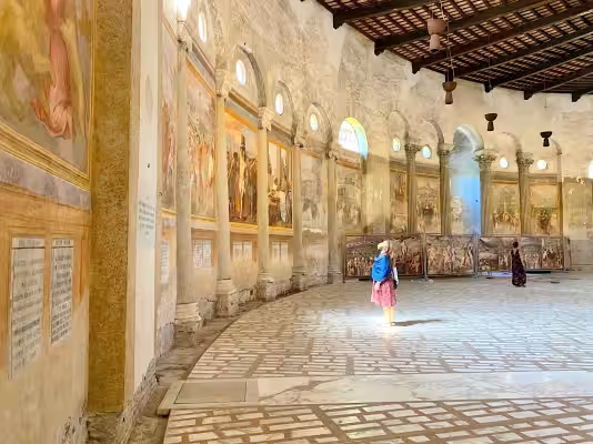 Visitor looking at the martyrdom frescoes inside Santo Stefano Rotondo